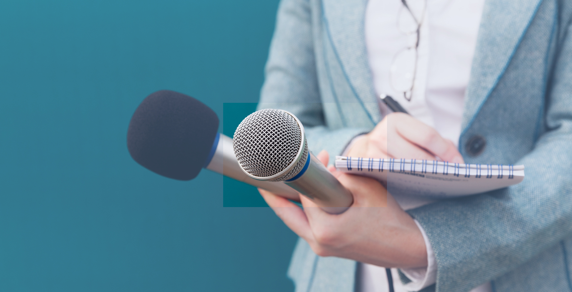 Reporter or TV journalist at news conference, holding microphone and writing notes